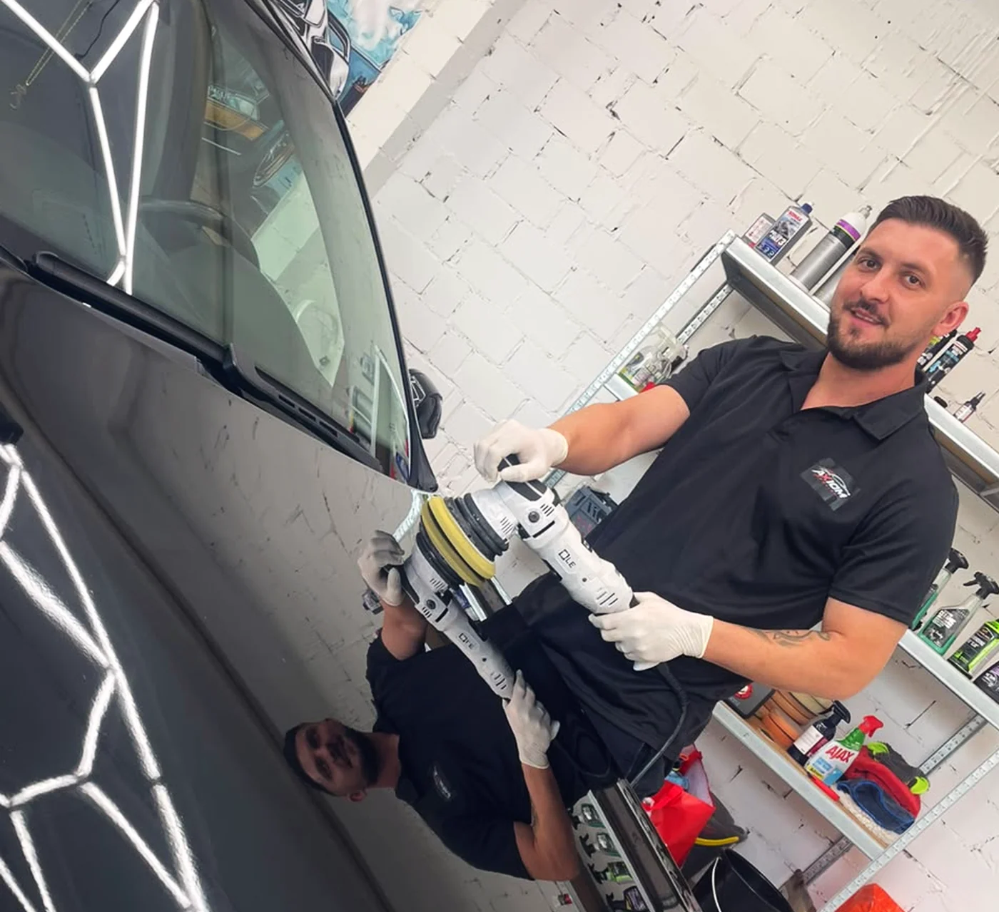 Florent Musliu poliert einen schwarzen BMW in der Werkstatt in Schaan