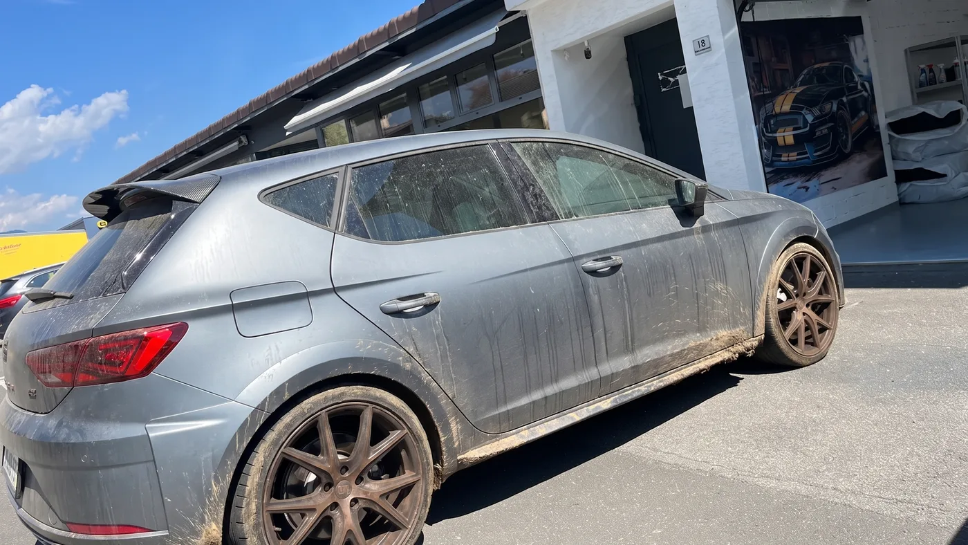 Vorher: Matt-grauer Seat Leon Cupra vor der Werkstatt in Schaan, verschmutzt vor und sauber nach der Lackaufbereitung